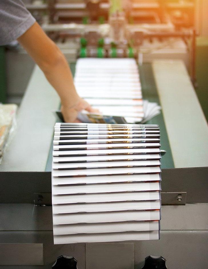 a stack of booklets sits on top of a printer